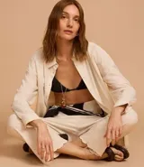 Pantalón recto de cintura alta confeccionado en viscolino color crudo, con elástico en la parte trasera de la cintura, cierre tradicional y textura de palmeras perforadas en el bajo.