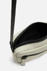 Bandolera negra de acabado engomado con correa ajustable y extraíble. Tiene un compartimento principal con cierre de cremallera, un bolsillo interior con cremallera y un bolsillo frontal con cremallera.
