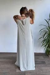 Vestido largo sin mangas, color verde claro, de corte holgado y tejido con textura acanalada.