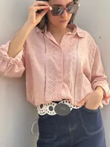 Camisa color rosa pálido con bordado inglés, cuello clásico, cierre frontal con botones, mangas largas con puños elásticos y corte holgado.