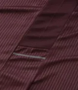 Remera deportiva de manga corta y cuello redondo, color beige claro, con textura acanalada vertical. Presenta detalles reflectantes en los hombros.