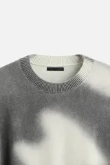 Jersey de punto gris con efecto tie-dye blanco, de corte relaxed fit, cuello redondo y mangas largas.