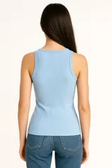Musculosa blanca de algodón con breteles anchos, corte al cuerpo y cuello redondo.