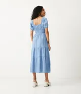 Vestido midi de jeans celeste, con escote cuadrado con lazo, mangas cortas abullonadas, cintura elastizada y falda escalonada con volados.