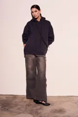 Sweater con capucha color negro, con cordones ajustables y botones en el escote.