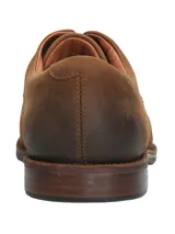 Zapato de vestir acordonado color marrón, de cuero engrasado, con suela de goma y taco bajo.