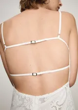 Vestido midi blanco de encaje con tirantes finos, escote cuadrado, corte en la cintura y falda acampanada. Presenta aberturas laterales en la cintura y bajo asimétrico.