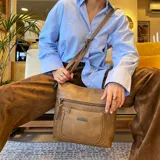 Bandolera negra de símil cuero con dos bolsillos frontales con cierre, un bolsillo trasero y tres bolsillos internos. Incluye correa larga regulable de símil cuero a tono.