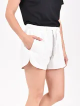 Short negro de tela suave con cintura elástica ajustable con cordón, bolsillos laterales y corte redondeado en los laterales.