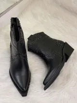 Botas cortas negras de cuero con punta fina, taco cuadrado y apliques de tachas plateadas.