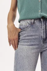 Pantalón de jean celeste de corte mom, con tachas plateadas.