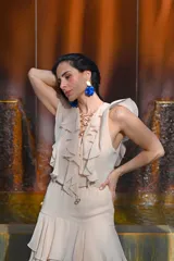 Vestido largo color beige, con escote en V, mangas cortas con volados y falda larga con volados en capas.