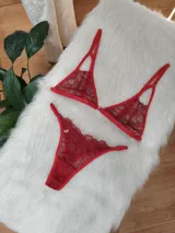 Conjunto de lencería rojo compuesto por un corpiño triangular de encaje con tirantes finos ajustables y una bombacha tipo colaless de encaje con bordes festoneados.