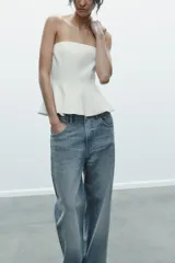 Top palabra de honor blanco con hombros descubiertos, corte ajustado y bajo con peplum.