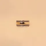 Anillo ancho en plata 925 con aplique central en oro 9k. Presenta bordes con diseño trenzado.