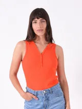 Musculosa naranja de punto canalé, con escote en V y cierre frontal con botones.