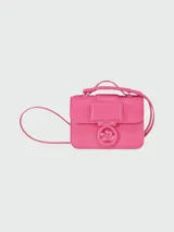 Bandolera Longchamp modelo Box-Trot XS, color fucsia, con correa fina ajustable y logo circular metálico en el frente.