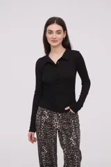 Remera de corte ajustado color negro con manga larga y cuello polo, botón frontal.