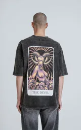 Remera negra con efecto nevado, corte oversize y estampa sublimada en la espalda con la carta del tarot 'El Diablo'.