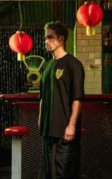 Remera negra de algodón con corte holgado y estampado frontal de un demonio con cuernos en color amarillo.