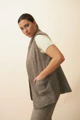 Chaleco color beige, entallado, con solapa, bolsillos plaqué y terminaciones envivadas.