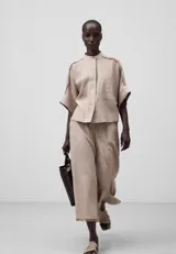 Pantalón cropped color beige de lino europeo y viscosa responsable, con trabillas, bolsillos laterales y traseros, pierna ancha y bajo desflecado.