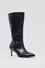 Bota de caña media de cuero negro, con punta fina y taco aguja de altura media.