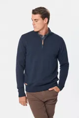 Sweater color beige de tejido de punto con cuello alto y cierre parcial con cremallera.