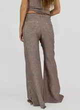 Pantalón de tiro alto color ladrillo, de corte palazzo con aberturas laterales en el ruedo y terminación desflecada.