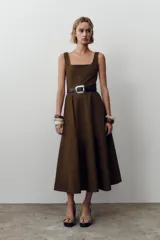 Vestido marrón midi de escote cuadrado y tirantes anchos, con cinturón negro y falda evasé. Cierre trasero con cremallera oculta.