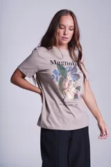 Remera color borgoña de corte recto y cuello redondo, con estampado de una flor de magnolia y texto en blanco.