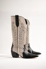 Botas texanas de cuero color beige con bordados negros y puntera negra.