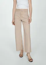Pantalón de jean color beige, de corte culotte, tiro alto y bajo deshilachado.