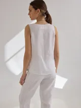 Musculosa blanca de lino con corte holgado y detalles de pespuntes en contraste.