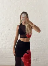 Conjunto de top corto y falda larga de tul negro con estampado de flores rojas.