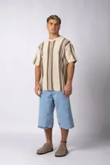 Remera de tejido de punto color crudo con rayas verticales marrones y negras, de manga corta y corte recto.