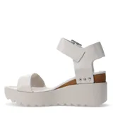 Sandalias de plataforma marca Bottero en color blanco hueso, con una tira ancha sobre los dedos y correa ajustable al tobillo mediante una hebilla metálica. La plataforma es de tono claro con suela dentada y cuenta con un detalle lateral de corcho decorado con tachas plateadas.