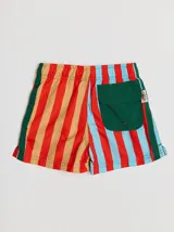 Short de baño azul con cintura elástica, rayas verdes en los laterales y bolsillo trasero con solapa roja y verde.