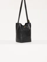 Cartera tipo tote confeccionada en cuero vacuno color crudo, con textura tipo piel de cocodrilo. Tiene correa larga al hombro y apliques metálicos con el logo de la marca. Incluye sobre interno desmontable con cierre.