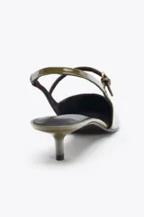 Zapato de tacón destalonado color verde oliva charolado, con pulsera con hebilla en la parte delantera, tira trasera con elástico y punta fina.