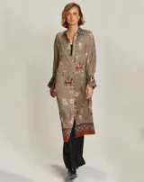 Vestido camisero midi con estampado de motivos ecuestres en tonos beige, marrón y rojo. Cuello camisero con estampado geométrico en blanco y negro. Manga larga con puños anchos con estampado geométrico en blanco y negro.