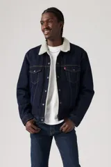 Campera de jean azul oscuro Levi's con cuello y forro de corderito color crema, cierre con botones metálicos, bolsillos frontales con solapa y bolsillos laterales.