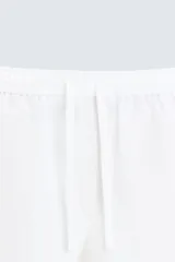 Pantalón de lino color marrón oscuro, de corte recto y relaxed fit. Tiene cintura elástica ajustable con cordón, bolsillos frontales y traseros de parche.