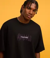 Remera negra de corte oversized, confeccionada en tejido de malla de algodón sostenible. Presenta cuello redondo, mangas cortas y estampa tribal con lettering en el frente.