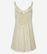 Vestido corto de corte evasé en color amarillo claro con estampado de cuadros. Posee escote en V, detalle de lazo central, fruncido bajo el busto y breteles finos regulables. Confeccionado en tejido de viscosa con forro de poliéster.