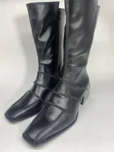 Bota de caña media color negro con puntera cuadrada y tres tiras horizontales con hebillas.