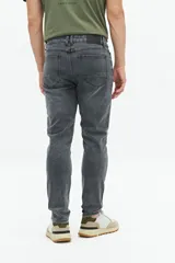 Jean slim azul oscuro, tiro medio, con pasacintos y confeccionado en 98% algodón y 2% spandex.