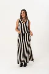 Pollera larga tejida a rayas verticales negras y beige, con pretina elástica y tajos laterales.