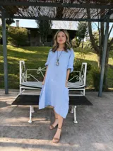 Vestido celeste de lino, corte oversize, con mangas cortas y bolsillos laterales.