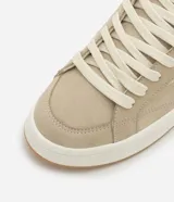 Championes casuales color beige, confeccionados en poliuretano con cordones y recortes.